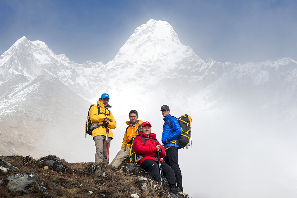 A team of four climbers make their way to Ama Dablam Base Camp, the 6856m peak seen in the distance, Khumbu Region, Himalayas, Nepal, Asia