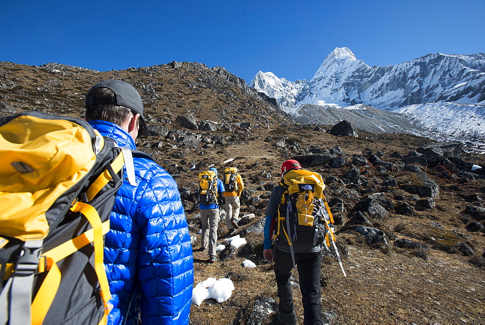 A team of four climbers make their way to Ama Dablam Base Camp, the 6856m peak seen in the distance, Khumbu Region, Himalayas, Nepal, Asia