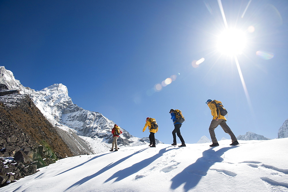 A team of four climbers make their way to Ama Dablam Base Camp, the 6856m peak seen in the distance, Khumbu Region, Himalayas, Nepal, Asia