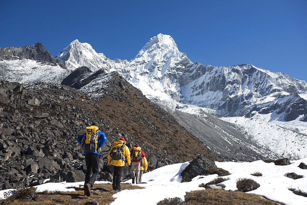 A team of four climbers make their way to Ama Dablam Base Camp, the 6856m peak seen in the distance, Khumbu Region, Himalayas, Nepal, Asia