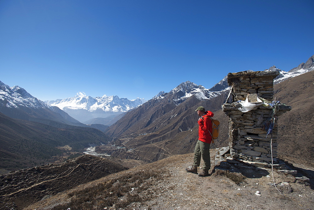 A trekker in the Everest region looks down on the Khumbu Valley towards Pangboche, Khumbu Region, Himalayas, Nepal, Asia