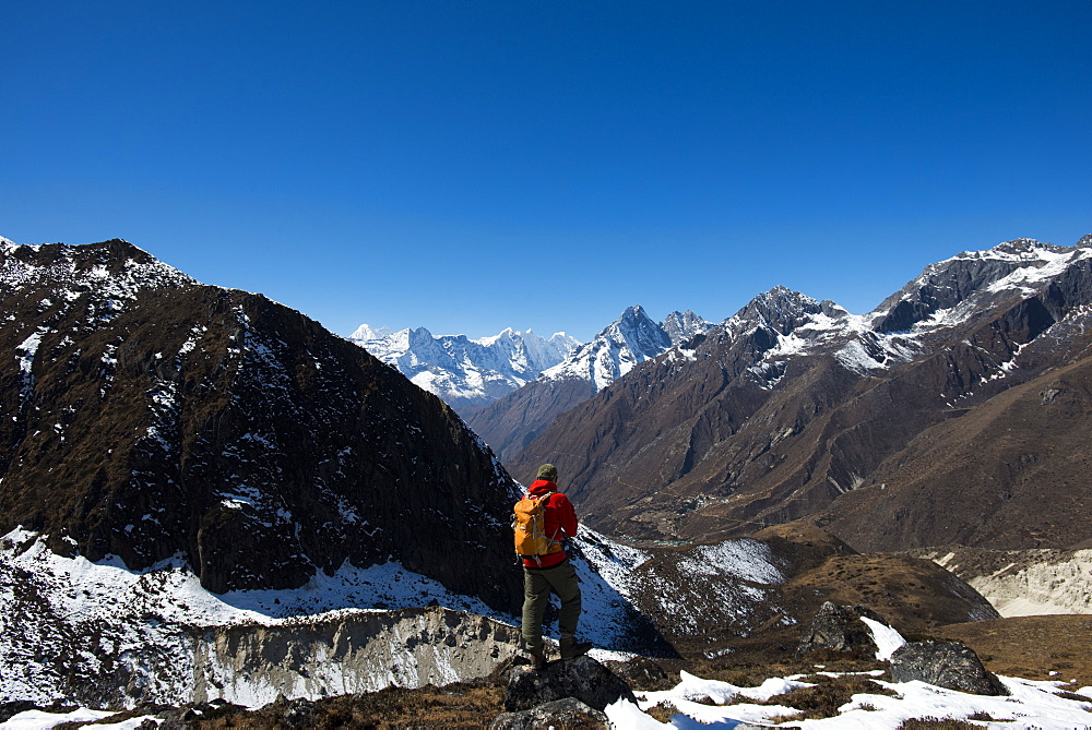 A trekker in the Everest region looks down on the Khumbu Valley towards Pangboche, Khumbu Region, Himalayas, Nepal, Asia