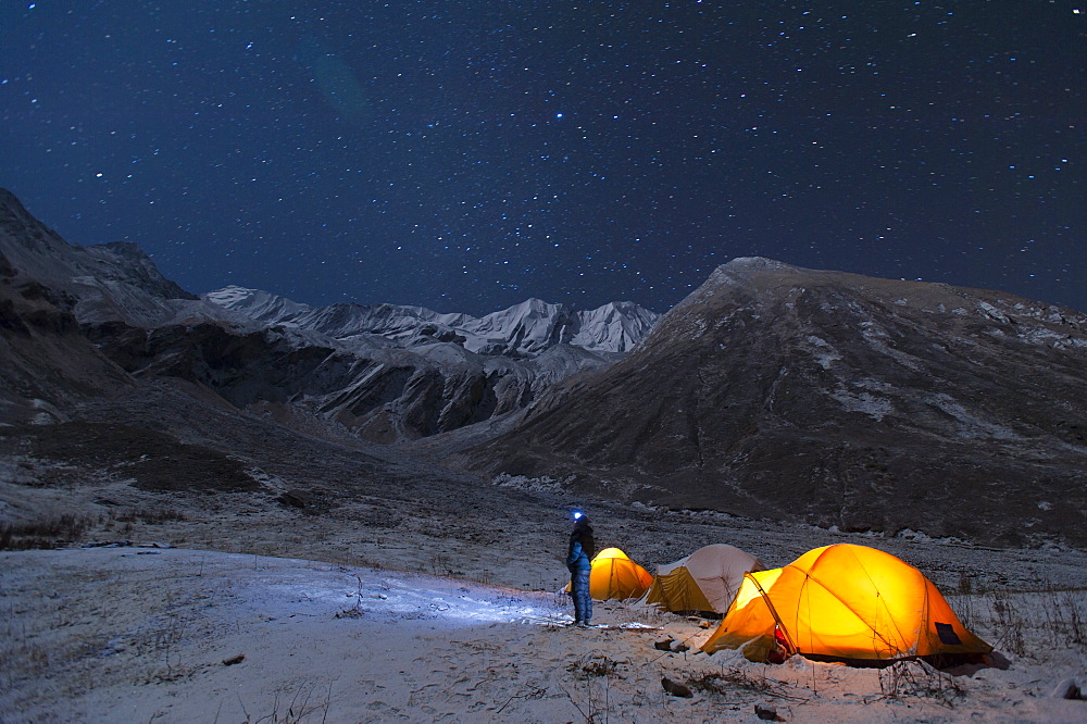 A man stands outside his tent to look at the stars in the little explored Juphal Valley in the remote Dolpa region of Nepal, Himalayas, Nepal, Asia