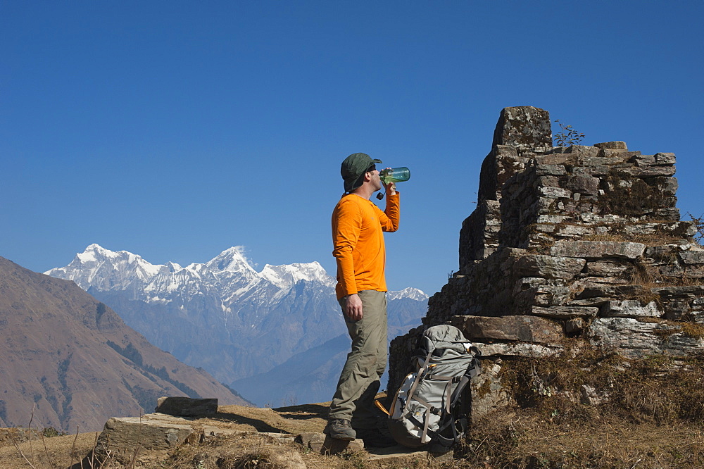 A trekker takes some well earned refreshment during the Manaslu circuit trek, Himalayas, Nepal, Asia