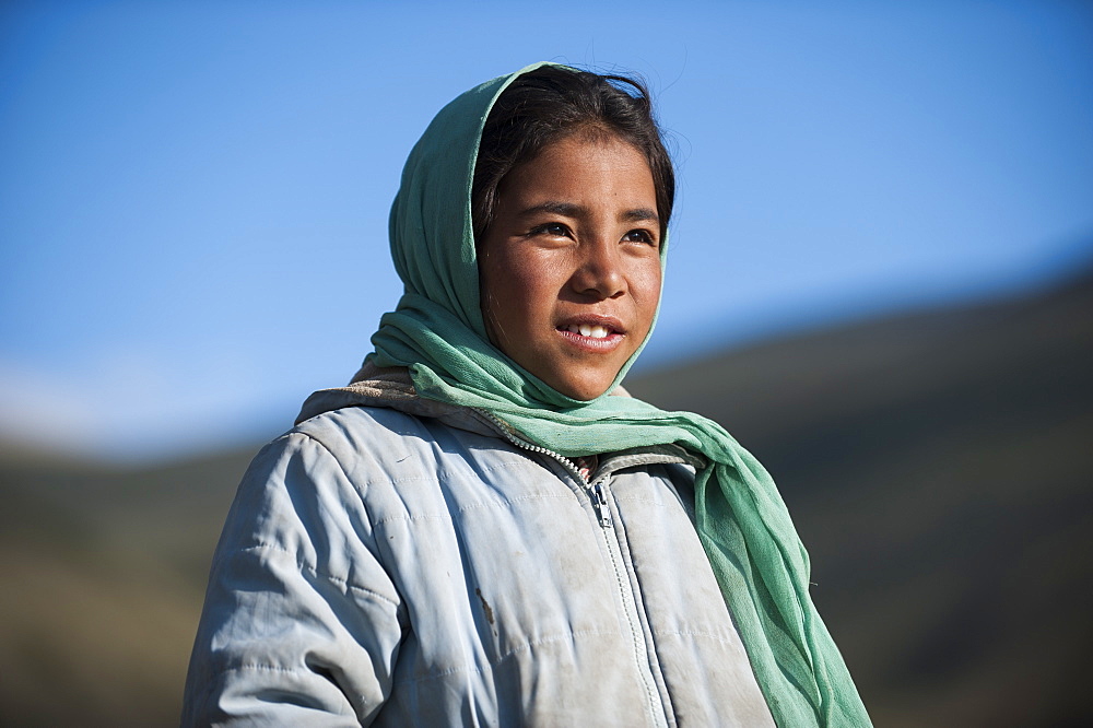 A nomad girl smiles as her father comes home from the hills, Ladakh, India, Asia