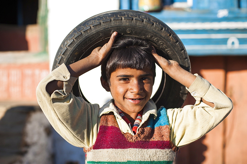 Children in India often utilise discarded wheels and turn them into toys, Uttarakhand, India, Asia