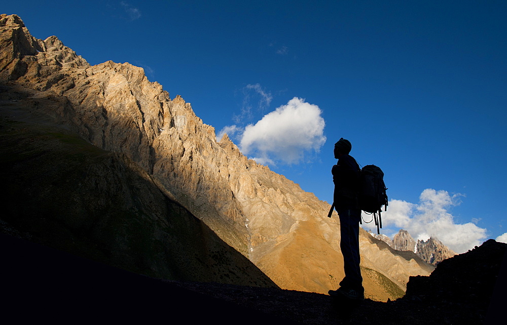 A trekker takes in the dramatic scenery from near the top of the Dung Dung La at 4710m during the Hidden valleys trek, Ladakh, India, Asia