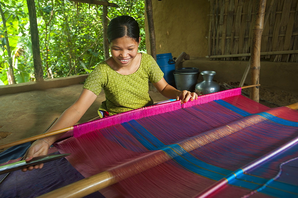 A woman weaves traditional clothes using a hand loom, Chittagong Hill Tracts, Bangladesh, Asia