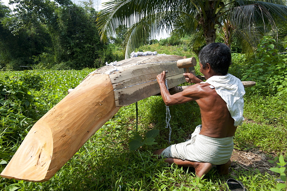 A man from Rangamati makes a traditional style dugout canoe, Chittagong Hill Tracts, Bangladesh, Asia