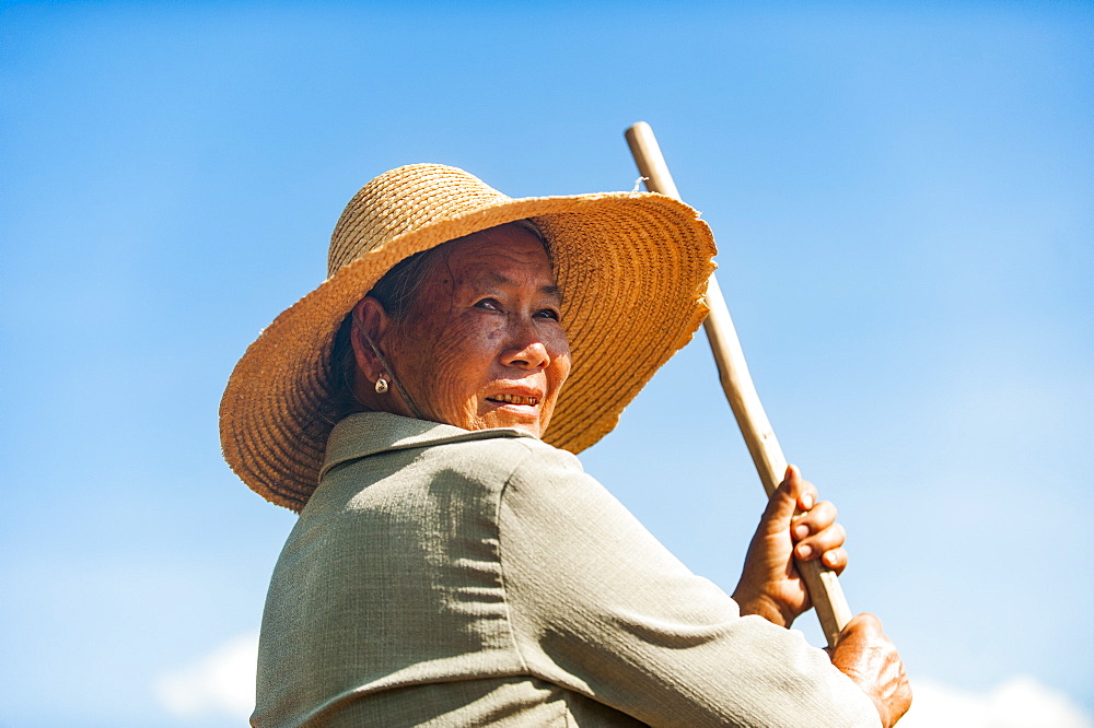 A farmer with a hand tool in Yunnan Province, China, Asia