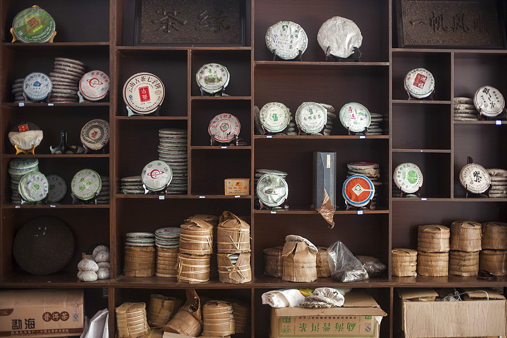 Tea cakes stacked up on shelves in a shop, Xishuangbanna, Yunnan Province, China, Asia