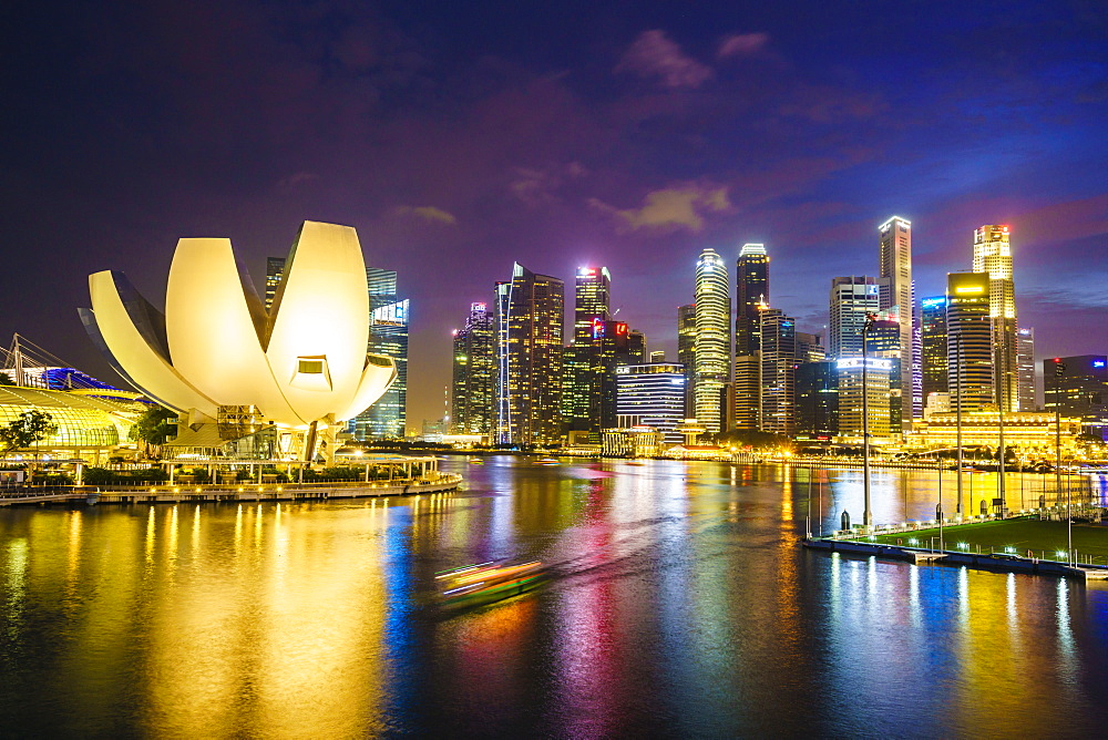 The lotus flower shaped ArtScience Museum overlooking Marina Bay with the city skyline beyond illuminated at night, Singapore, Southeast Asia, Asia