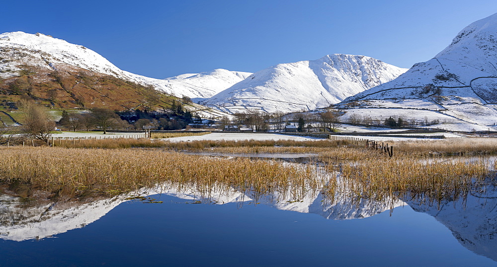 Snowclad sunlit fells around Hartstop reflected in Brothers Water, Lake District National Park, UNESCO World Heritage Site, Cumbria, England, United Kingdom, Europe