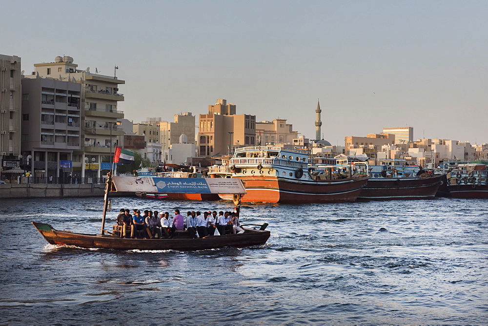 A water taxi carrying passengers crosses Dubai Creek, Dubai, United Arab Emirates, Middle East