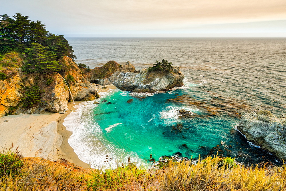 Smoky skies from a nearby wildfire turn the land orange at McWay Falls, California, United States of America, North America