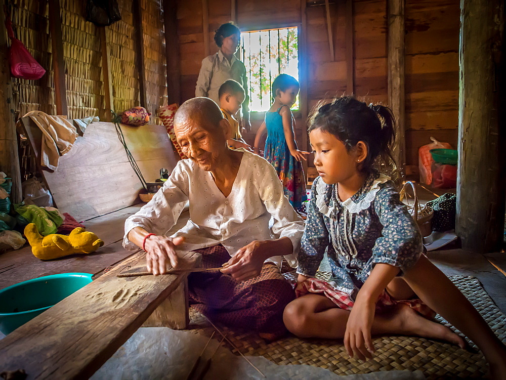 Old woman making incense as child watches, village near Siem Reap, Cambodia, Indochina, Southeast Asia, Asia