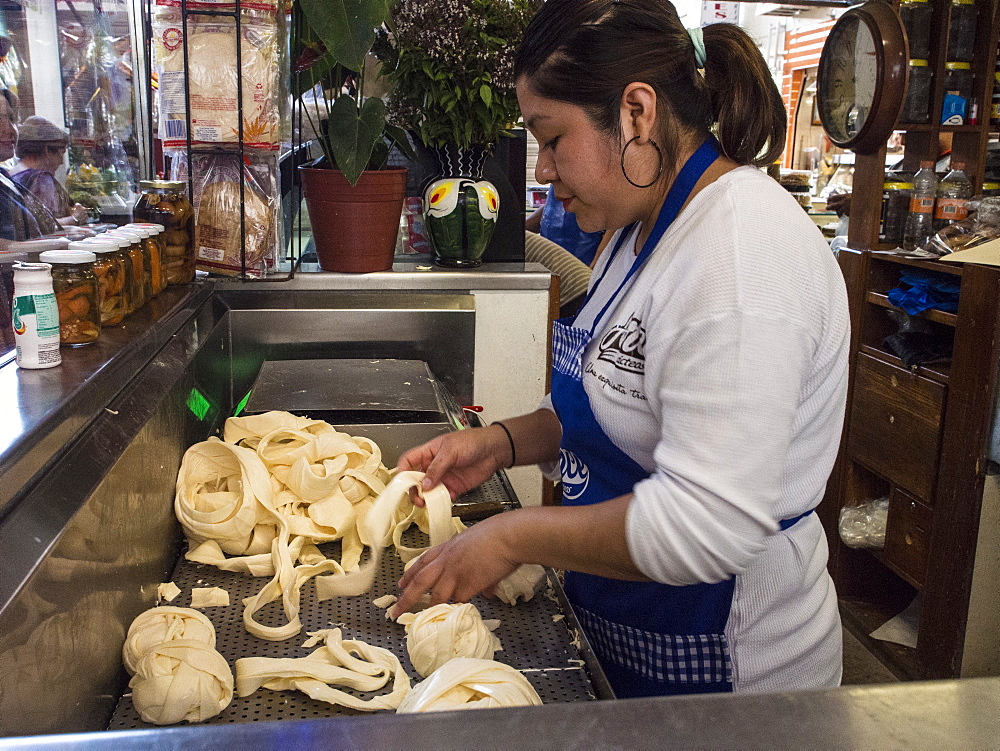 Woman selling Oaxacan quesillo, traditional rolled string cheese, in a market, Oaxaca, Mexico, North America