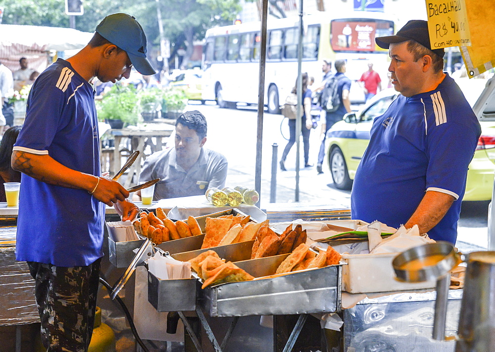 Market workers prepare a fried dish, known as pastel which can be served with cheese or meat, Rio de Janeiro, Brazil, South America