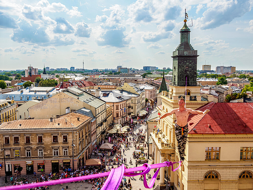 Man highlining with City Hall and Krakowskie Przedmiescie Promenade in the background, Urban Highline Festival, Lublin, Poland, Europe