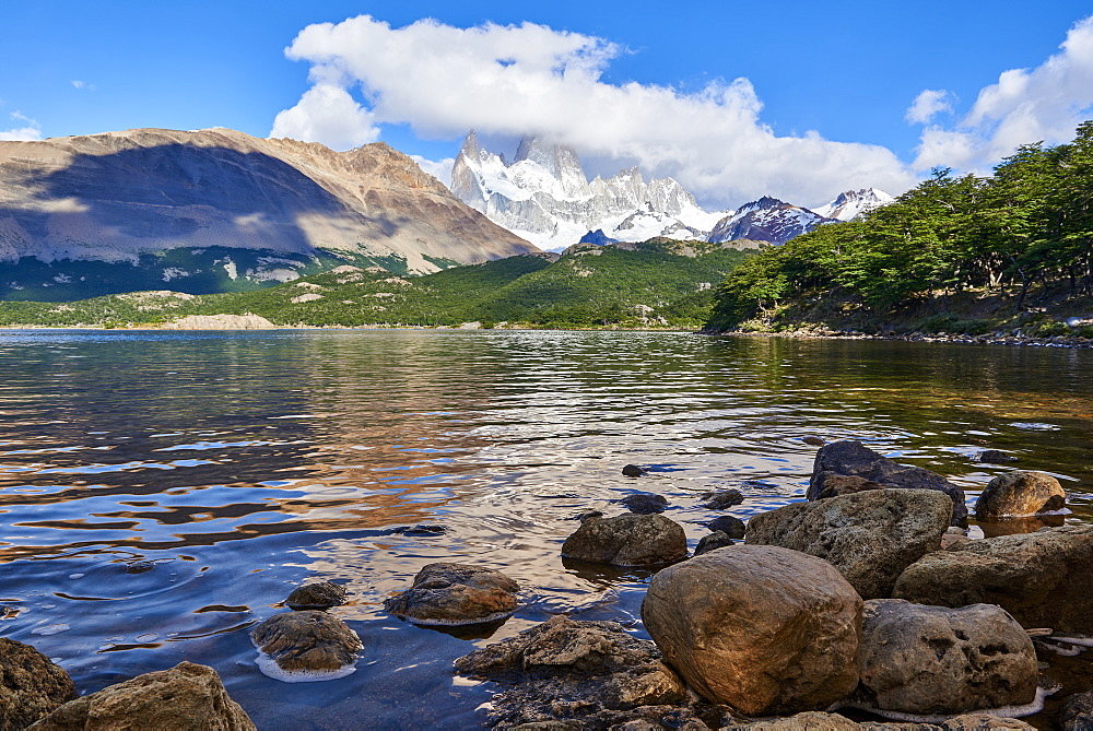 Wide angle shot of Capri Lagoon featuring Monte Fitz Roy in the background and rocks in the foreground, Patagonia, Argentina, South America