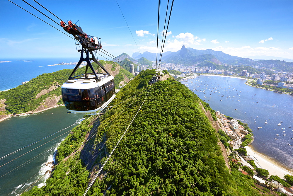 A motion blurred cable car approaches the station atop Sugarloaf mountain, with sweeping view of Rio de Janeiro behind, Rio de Janeiro, Brazil, South America