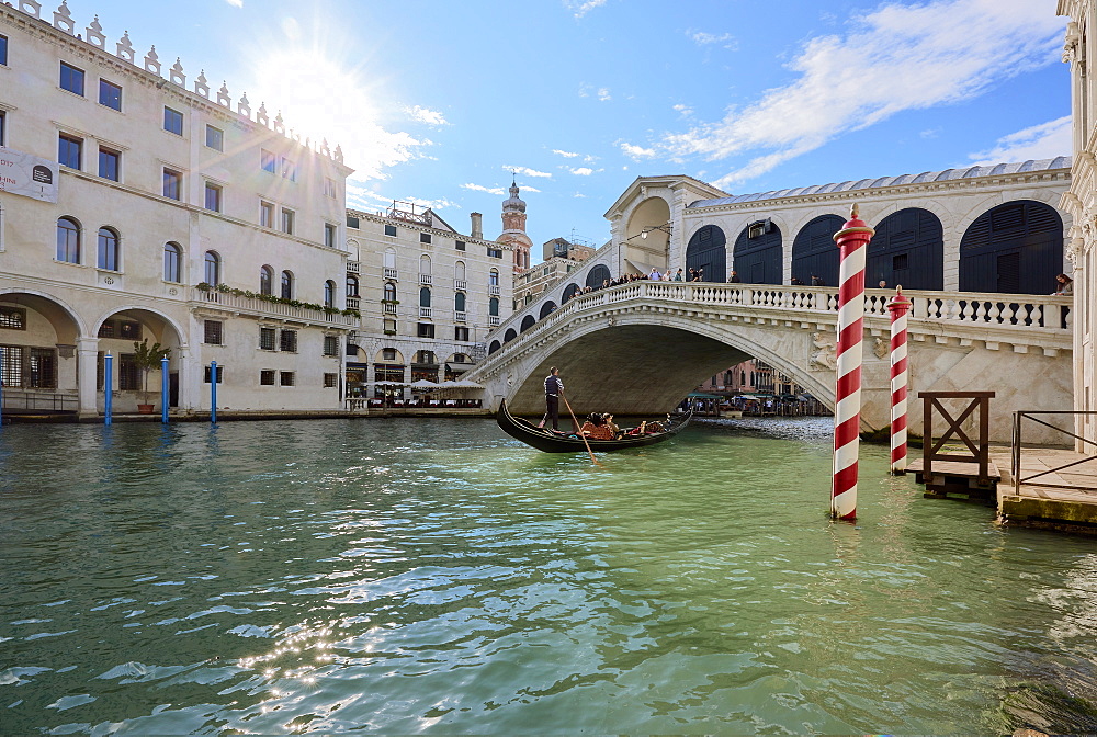 A gondolier rowing under Rialto Bridge in Venice, UNESCO World Heritage Site, Veneto, Italy, Europe