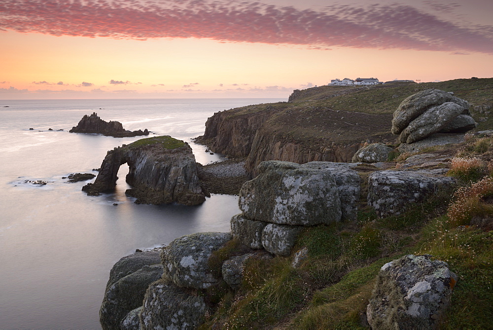 A colourful sunset overlooking the islands of Enys Dodnan and the Armed Knight at Lands End, Cornwall, England, United Kingdom, Europe