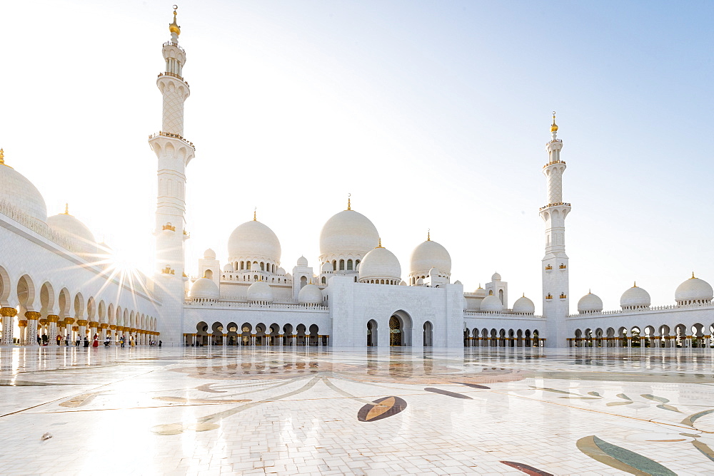 The domes and minarets of Abu Dhabi's Grand Mosque viewed across the large marble tiled central courtyard, Abu Dhabi, United Arab Emirates, Middle East