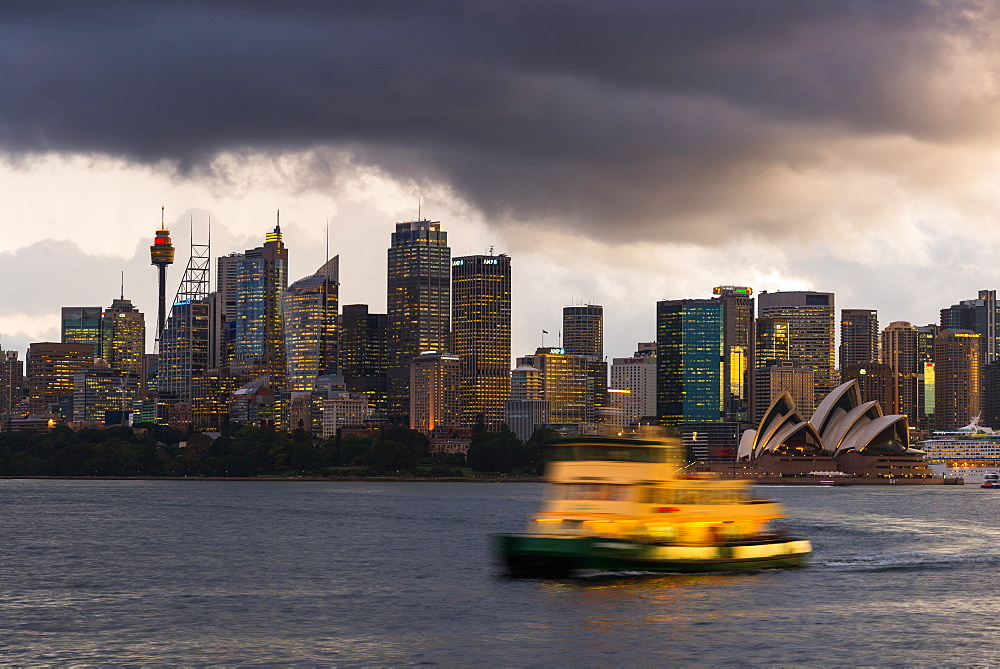 A ferry in Sydney Harbour at dusk with the Opera House and city skyline, Sydney, New South Wales, Australia, Pacific