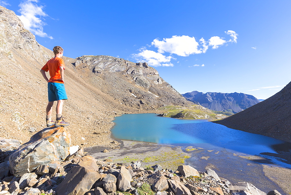 A boy looks at Lai da Fasch'Alba from above, Val Tasna, Engadine Valley, Graubunden, Switzerland, Europe