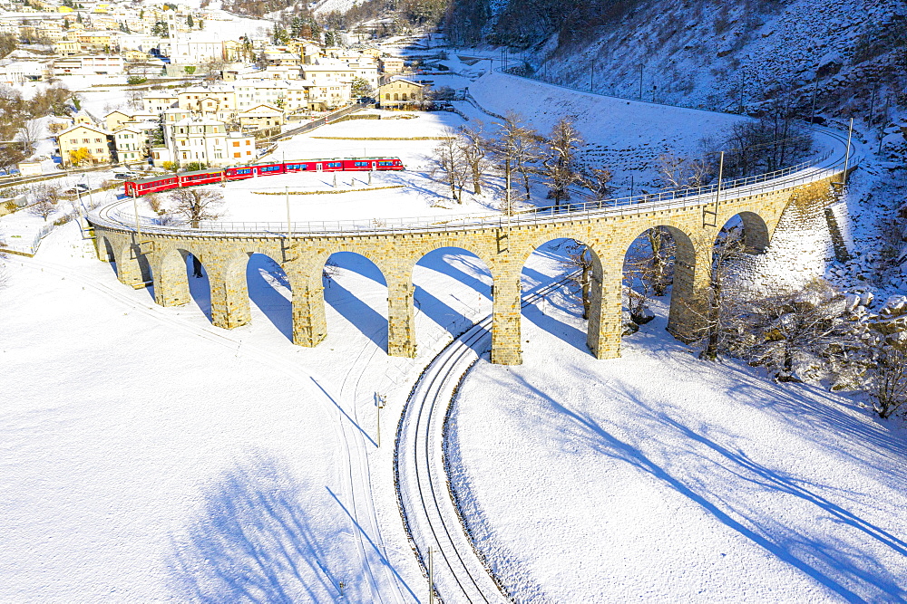 Bernina Express passes over the helical (spiral) viaduct of Brusio, UNESCO World Heritage Site, Valposchiavo, Canton of Graubunden, Switzerland, Europe