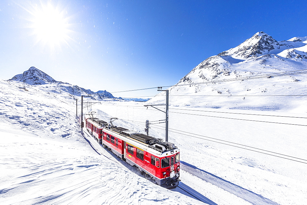 Bernina Express transit along Lago Bianco in winter, Bernina Pass, Engadine, Canton of Graubunden, Switzerland, Europe