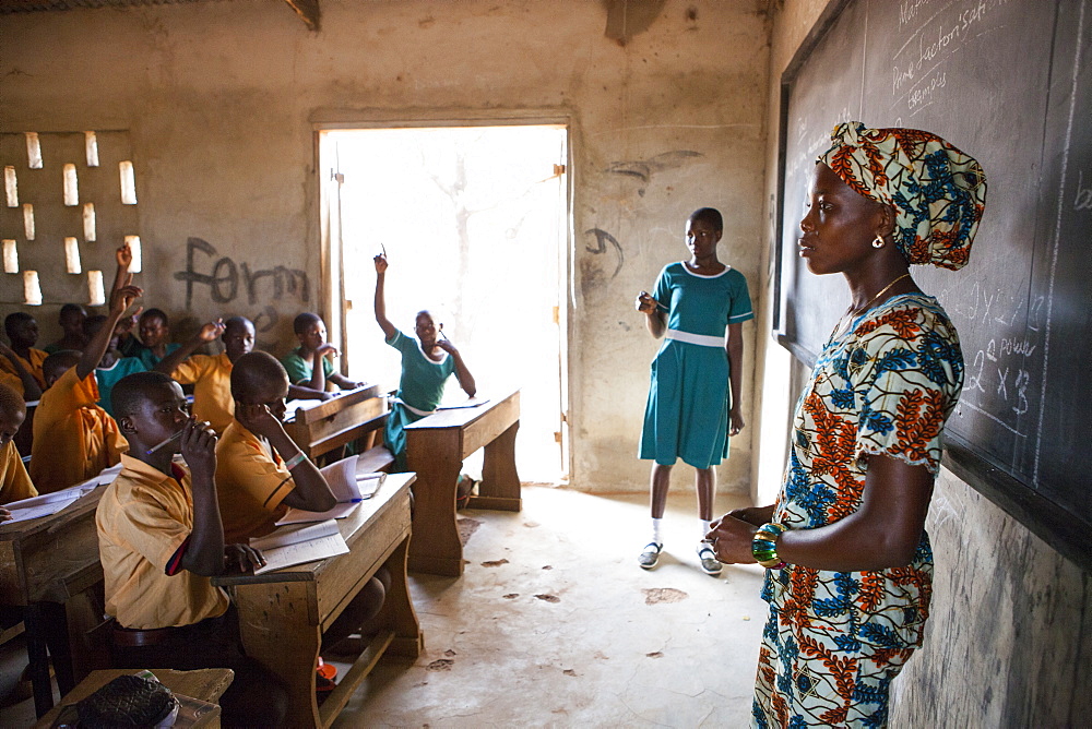 A female teacher teaching at the front of the classroom at a primary school in Ghana, West Africa, Africa