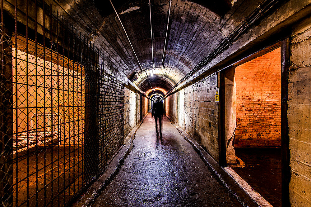 A tourist walking through The Underground German Hospital in Guernsey, Channel Islands, United Kingdom, Europe