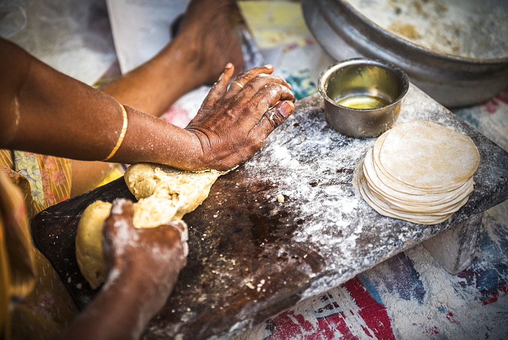 Portrait of an Indian woman making chapati in Fort Kochi (Cochin), Kerala, India, Asia