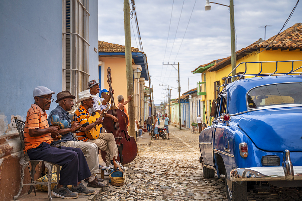 Elderly Cubans playing music on the street, American classic car, Trinidad, Sancti Spiritus Province, Cuba, West Indies, Caribbean, Central America