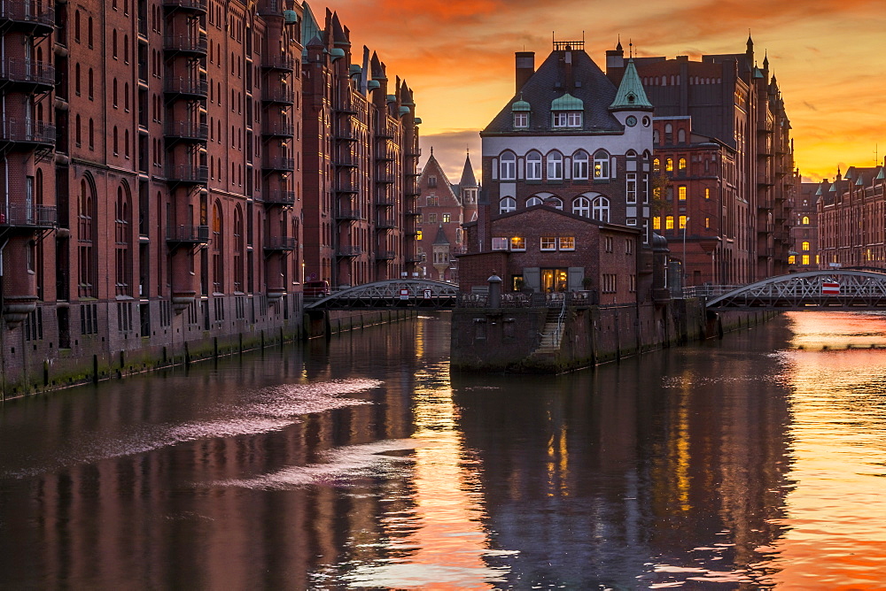 Wasserschloss building at the historical warehouse complex (Speicherstadt) seen from Poggenmuehlenbrucke during sunset, Hamburg, Germany, Europe