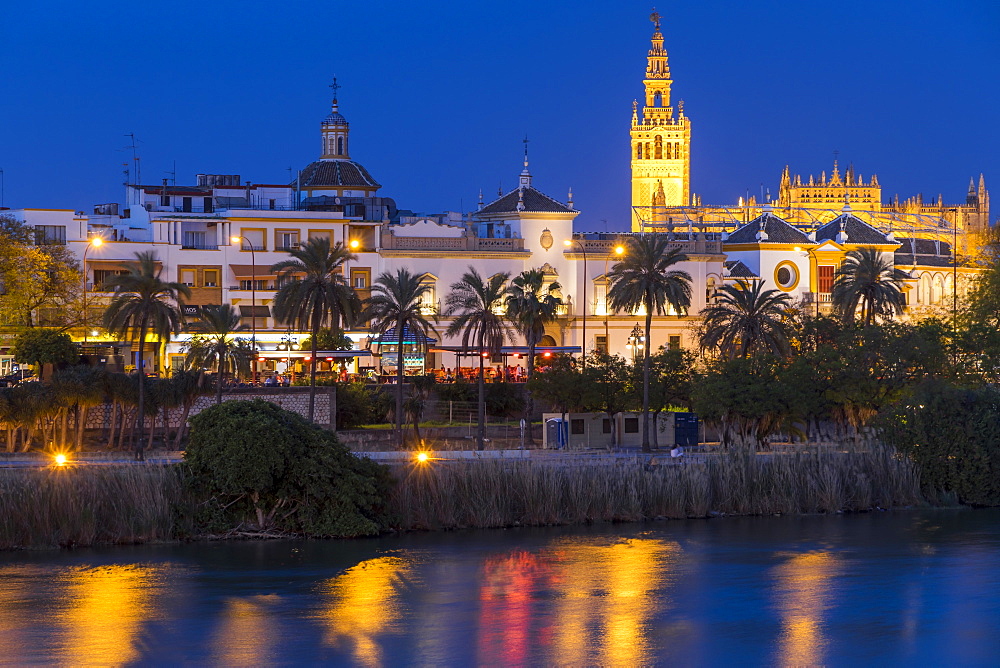 The Giralda Bell Tower and Plaza de Toros seen from the banks of Guadalquivir River at dusk, Seville, Andalusia, Spain, Europe