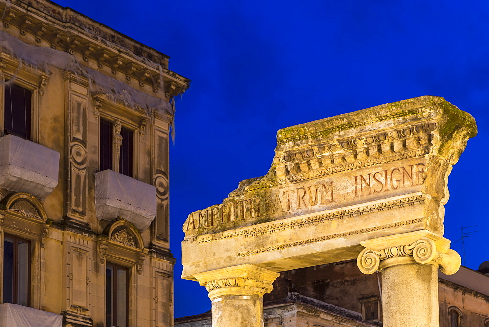 Illuminated entrance gate of the ancient Amphitheatre of Catania at dusk, Catania, Sicily, Italy, Europe