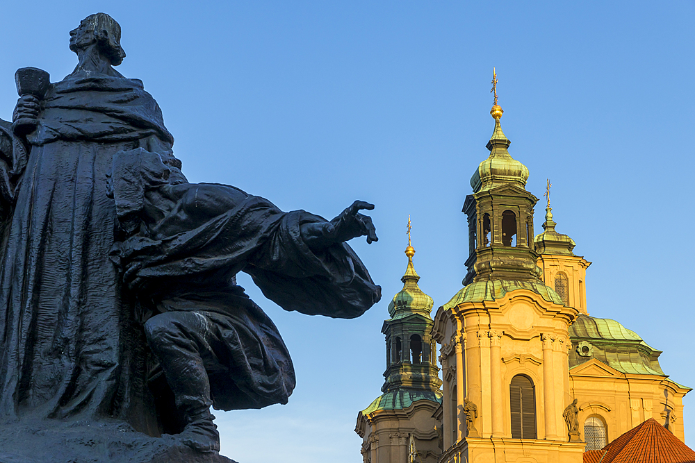 Jan Hus Monument and St. Nicholas' Church seen from the old town market square in the morning, Prague, Bohemia, Czech Republic, Europe