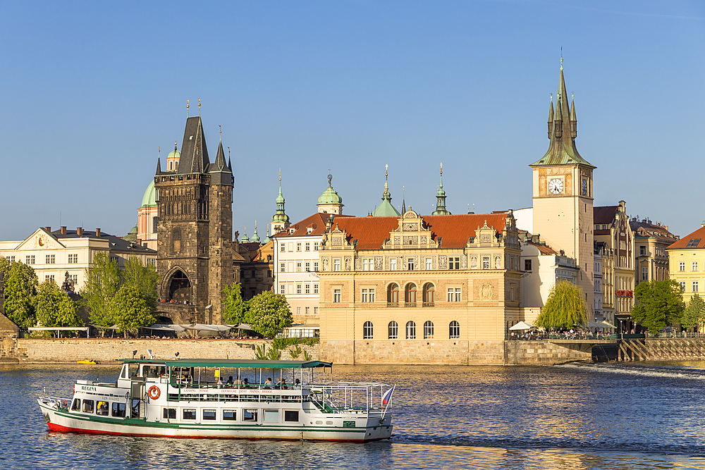 Tourist boat on Vltava River passing the Old Town Bridge Tower and the Old Town Water Tower, Prague, Bohemia, Czech Republic, Europe