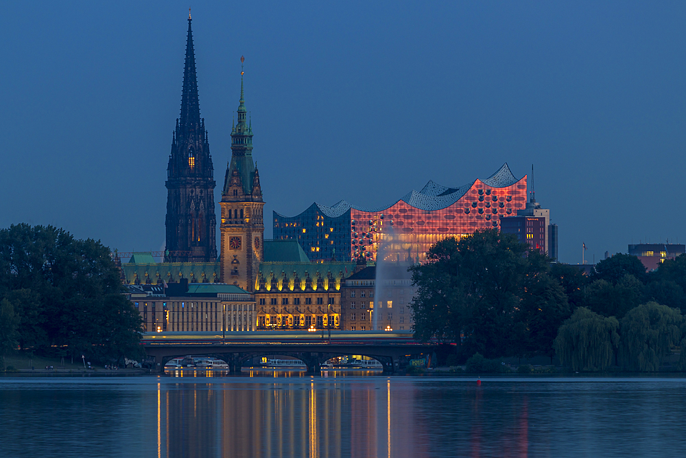 View from the Outer Alster Lake to the Elbphilharmonie, the town hall and St. Nikolai Memorial at dusk, Hamburg, Germany, Europe