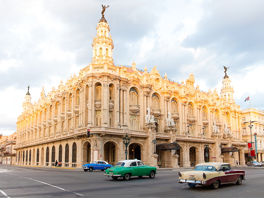 Old American cars drive past the Gran Teatro de La Habana in Havana, Cuba, West Indies, Caribbean, Central America