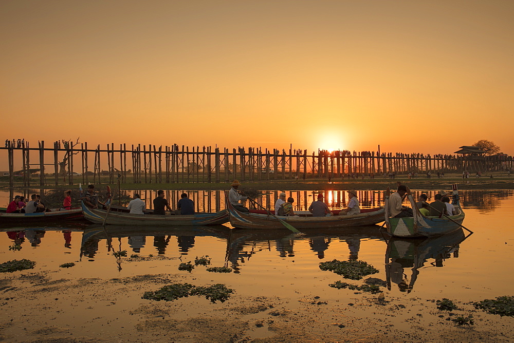 Sunset at U Bein bridge, oldest and longest teak bridge in the world, across Lake Taungthaman, Amarapura, Myanmar (Burma), Asia