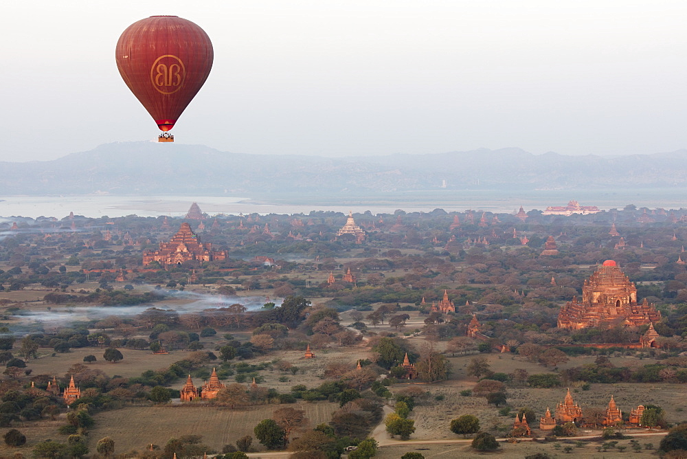 Hot air balloon flies over ancient Buddhist temples at dawn, Bagan (Pagan), Mandalay Region, Myanmar (Burma), Asia