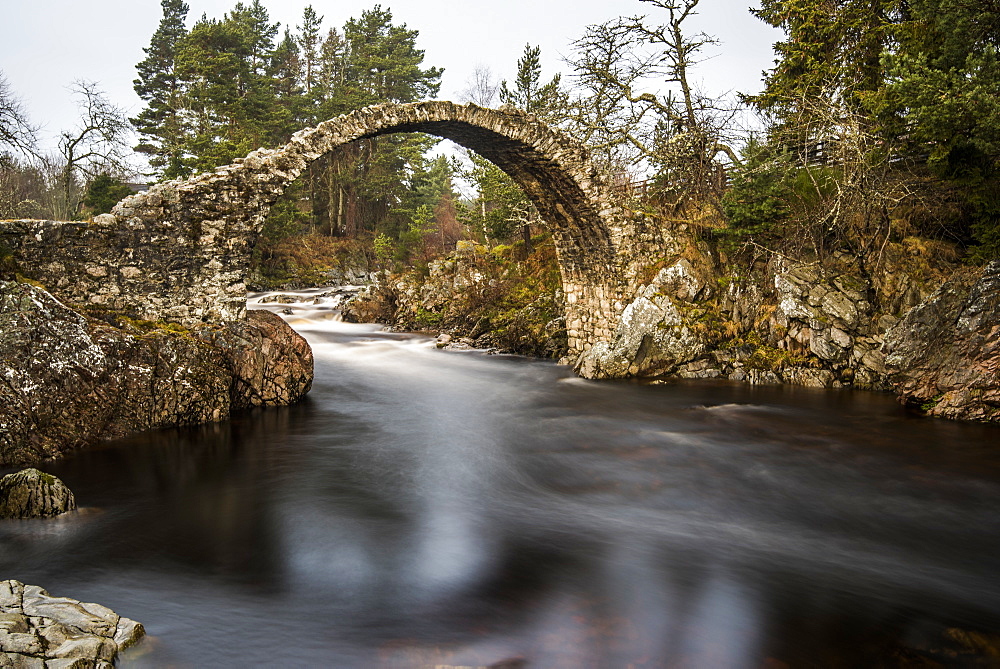 The old packhorse bridge built in 1717 over the River Dulnain in the village of Carrbridge near Aviemore in the Cairngorms, Scotland, United Kingdom, Europe