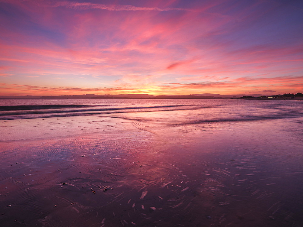 Really strong afterglow and interesting wispy clouds, reflected in the sea at Exmouth, Devon, England, United Kingdom, Europe