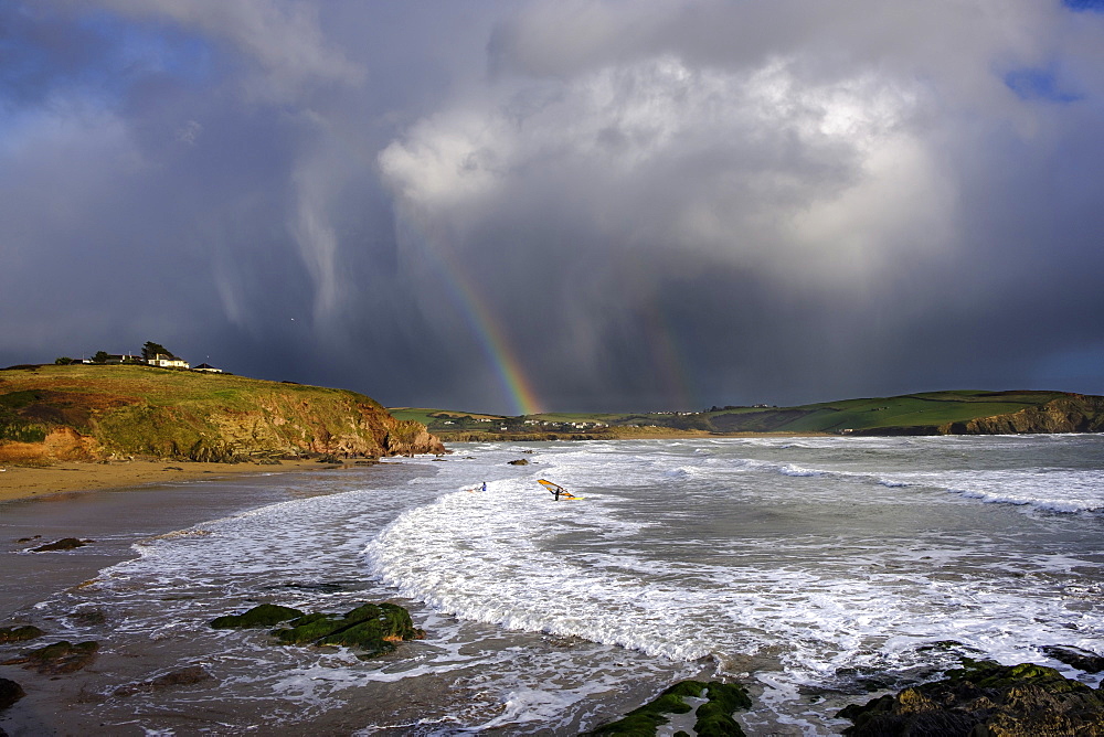 A windsurfer waits to sail out through the surf in stormy weather at Bigbury-on-Sea, Devon, England, United Kingdom, Europe