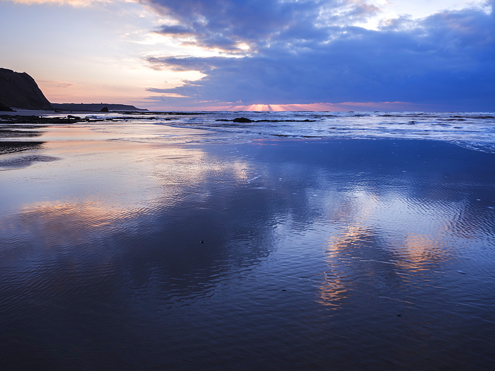 Sun rays and clouds reflections on the beach at Orcombe Point, Exmouth, Devon, England, United Kingdom, Europe