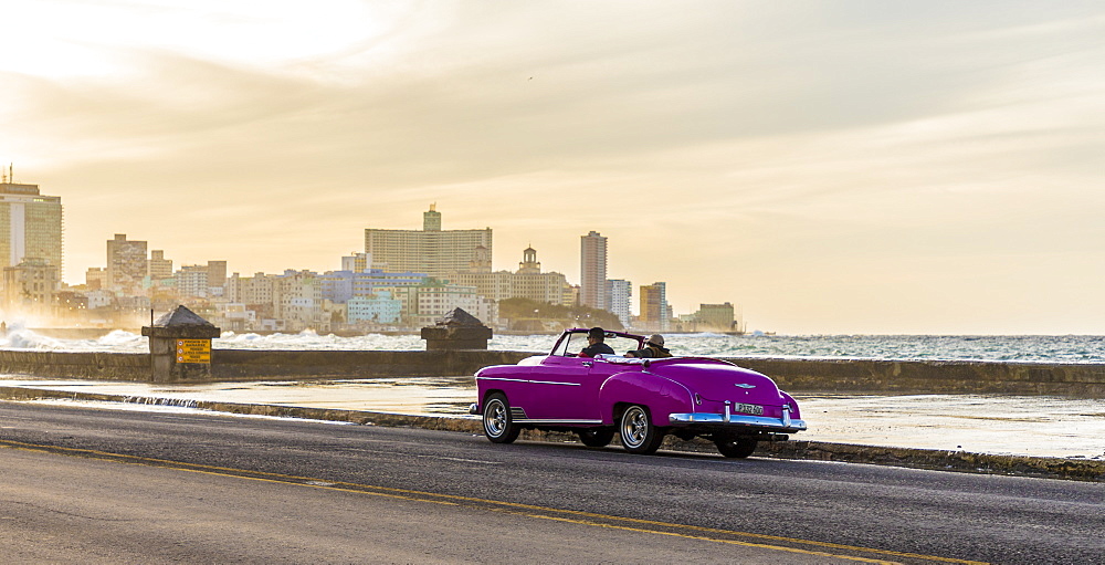 A vintage American car driving along the Malecon in Havana, Cuba, West Indies, Caribbean, Central America